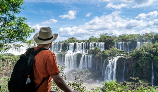 Young man admiring the impressive Iguazu Falls, Argentina.